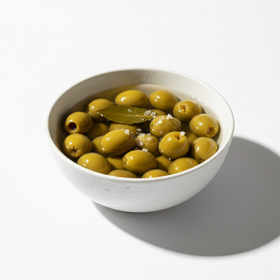 Pitted green Manzanilla olives in a white ceramic bowl