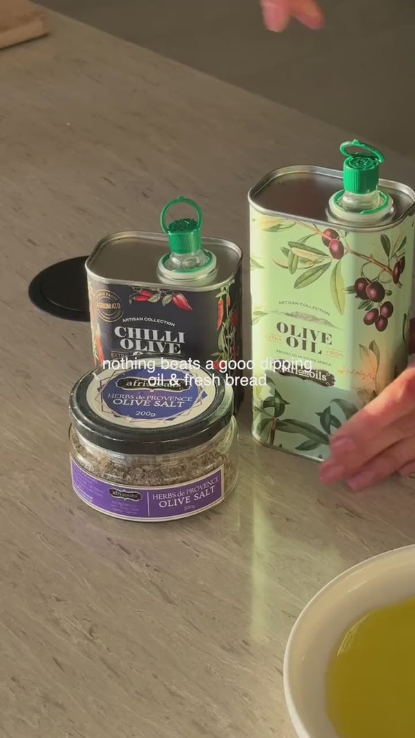 Pouring African Oils olive oil into a bowl and dipping fresh bread